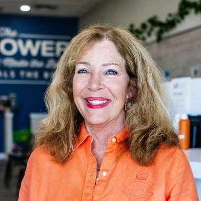 Karen Harris smiling in an orange shirt.