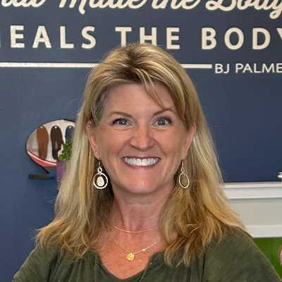 Tracy Piekarz Smiling In Front Of Banner